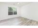 Bright bedroom featuring wood-look flooring, a ceiling fan, and a large window offering ample natural light at 11411 Ridge Oak Dr, Charlotte, NC 28273