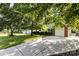 Charming home featuring a well-manicured lawn, mature trees, and a long driveway leading to an attached two-car garage at 11411 Ridge Oak Dr, Charlotte, NC 28273