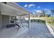 Covered back porch with a porch swing and a stone patio with a treed landscape and blue sky at 1169 Hollis Sw Cir, Concord, NC 28025