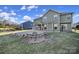 Backyard features a covered porch, patio, stone firepit, and lush greenery, great for relaxing at 1169 Hollis Sw Cir, Concord, NC 28025