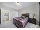 Bedroom with a dark wood platform bed, neutral carpet, lamp, and an ensuite bathroom at 1169 Hollis Sw Cir, Concord, NC 28025