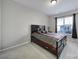 Bedroom with a dark wood platform bed, neutral carpet, and a large window with natural light at 1169 Hollis Sw Cir, Concord, NC 28025