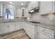 Well-lit kitchen featuring white cabinets, granite countertops, stainless steel appliances and tile backsplash at 1169 Hollis Sw Cir, Concord, NC 28025