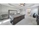 Spacious primary bedroom with tray ceiling, fan and access to en suite bathroom at 1169 Hollis Sw Cir, Concord, NC 28025