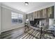 Bright home office features a modern glass desk, wood-look accent wall, and sun-filled window at 1169 Hollis Sw Cir, Concord, NC 28025