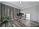 Bright and airy home office with modern glass desk and stylish wood-look accent wall at 1169 Hollis Sw Cir, Concord, NC 28025