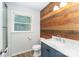Modern bathroom featuring a wood accent wall, sink, and toilet at 133 Pecan Ln, Salisbury, NC 28146
