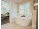 Bright bathroom features a soaking tub with tile flooring and beadboard trim at 146 Bullfinch Rd, Mooresville, NC 28117