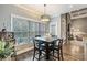 Dining area with stylish light fixture, fireplace, and large windows overlooking greenery at 146 Bullfinch Rd, Mooresville, NC 28117