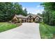 Beautiful stone home showcasing mature trees, a long driveway and meticulous landscaping at 146 Bullfinch Rd, Mooresville, NC 28117