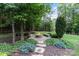 Backyard space featuring a fire pit surrounded by lush landscaping and stone pavers at 146 Bullfinch Rd, Mooresville, NC 28117