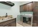 Laundry room with stainless washer and dryer, a utility sink, and storage cabinets at 146 Bullfinch Rd, Mooresville, NC 28117