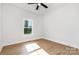 Well-lit bedroom with wood-look flooring, a ceiling fan, and a window overlooking the outdoors at 150 Autumn Blaze Rd, China Grove, NC 28023