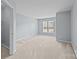 Empty bedroom with neutral carpet, light gray walls and large window at 157 Talbert Town Loop, Mooresville, NC 28117