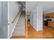 Entryway with hardwood floors and carpeted stairs leading to the upper level with adjacent kitchen at 157 Talbert Town Loop, Mooresville, NC 28117
