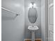 Compact half-bathroom with a pedestal sink, oval mirror, and modern fixtures, offering functionality at 157 Talbert Town Loop, Mooresville, NC 28117