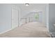 Upstairs hallway featuring neutral colored walls, carpet, and white trim with railing at 157 Talbert Town Loop, Mooresville, NC 28117