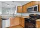 A kitchen equipped with stainless steel appliances and wooden cabinetry, offering a functional space for cooking at 157 Talbert Town Loop, Mooresville, NC 28117