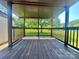 Cozy covered back porch with wooden flooring, perfect for outdoor relaxation and enjoying scenic views at 1678 Nelson Dr, Newton, NC 28658