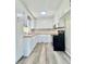 Bright, galley-style kitchen featuring white cabinets, butcher block countertops, and stainless steel appliances at 1678 Nelson Dr, Newton, NC 28658
