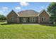 Wide shot of the back of a brick home with a pristine lawn and a comfortable patio at 170 Saint James Way, Salisbury, NC 28147