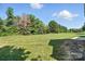 The backyard is a spacious grassy area with trees and a playset for outdoor enjoyment at 170 Saint James Way, Salisbury, NC 28147
