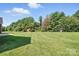 A lush, expansive backyard featuring green grass, mature trees, and outdoor play equipment at 170 Saint James Way, Salisbury, NC 28147