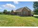 Expansive backyard with a brick home, lush lawn and mature trees offers serene outdoor living at 170 Saint James Way, Salisbury, NC 28147