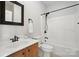 A bathroom with a vanity, toilet, mirror and shower-tub combo with dark fixtures at 170 Saint James Way, Salisbury, NC 28147