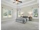 An airy bedroom featuring neutral carpeting, tray ceilings, and large windows at 170 Saint James Way, Salisbury, NC 28147