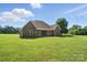 Brick home backyard features a covered patio, manicured lawn, and mature trees for outdoor enjoyment at 170 Saint James Way, Salisbury, NC 28147