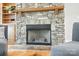 Close up of stone fireplace with wood mantle, including surrounding wood cabinets and shelves at 170 Saint James Way, Salisbury, NC 28147