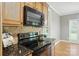 Kitchen boasts black oven and range top, and brown tiled backsplash under wooden cabinets at 170 Saint James Way, Salisbury, NC 28147