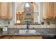 View of stainless steel kitchen sink, granite countertops, and wooden cabinets at 170 Saint James Way, Salisbury, NC 28147