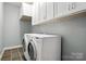 Well-lit laundry area with top-load washer and dryer, storage cabinets, and tile flooring at 170 Saint James Way, Salisbury, NC 28147