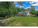 Spacious backyard features a well-maintained lawn, mature trees, and a charming home with deck at 1921 Williford Woods Ln, Rock Hill, SC 29730