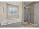 Bright bathroom featuring a garden tub beneath a decorative window and a stand up shower at 1921 Williford Woods Ln, Rock Hill, SC 29730