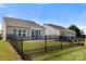 Backyard view with lawn, black fence, and exterior of home with screened-in porch at 20241 Dovekie Ln, Indian Land, SC 29707
