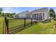 Backyard view with lawn, black fence, and exterior of home with screened-in porch at 20241 Dovekie Ln, Indian Land, SC 29707