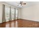 Spacious bedroom with three large windows, hardwood floors, and a ceiling fan at 20241 Dovekie Ln, Indian Land, SC 29707