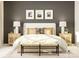 Cozy bedroom with framed art, lamps, textured nightstands, and a comfortable bed with pillows at 233 Runner Stone Ln, Fort Mill, SC 29715