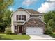 Charming two-story home featuring stone accents, a two-car garage, and a welcoming front entrance at 233 Runner Stone Ln, Fort Mill, SC 29715