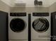 Functional laundry room showcasing side-by-side washer and dryer units and overhead shelving at 233 Runner Stone Ln, Fort Mill, SC 29715