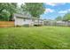 A sizable backyard with a verdant lawn extending to a wooden deck and a secure, fenced boundary at 2509 1St St, Statesville, NC 28677