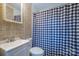 Bathroom with tile surround, white vanity, toilet, and blue and white shower curtain at 2509 1St St, Statesville, NC 28677