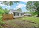 Quaint home featuring a well-kept front yard with mature trees, partial fence and gravel driveway at 2509 1St St, Statesville, NC 28677