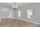 Bright and open dining room with laminate wood floors, two windows and a decorative chandelier at 275 Dorothy Dr, China Grove, NC 28023