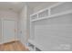 Bright entryway featuring a white door, wood-look floors, and a custom built-in storage bench with shelving at 275 Dorothy Dr, China Grove, NC 28023