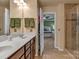 Bright bathroom with dual sinks, wood cabinets, and a glass door shower visible from the doorway at 3159 Hartson Pointe Dr, Fort Mill, SC 29707