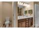 Bathroom featuring double vanity sinks with dark wood cabinetry, enhanced by elegant lighting and decor at 3159 Hartson Pointe Dr, Fort Mill, SC 29707